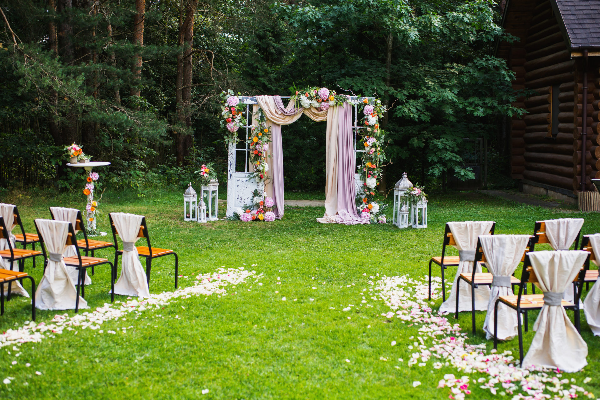 casamento simples no campo com panos rosas, flores coloridas e pétalas de rosas no chão