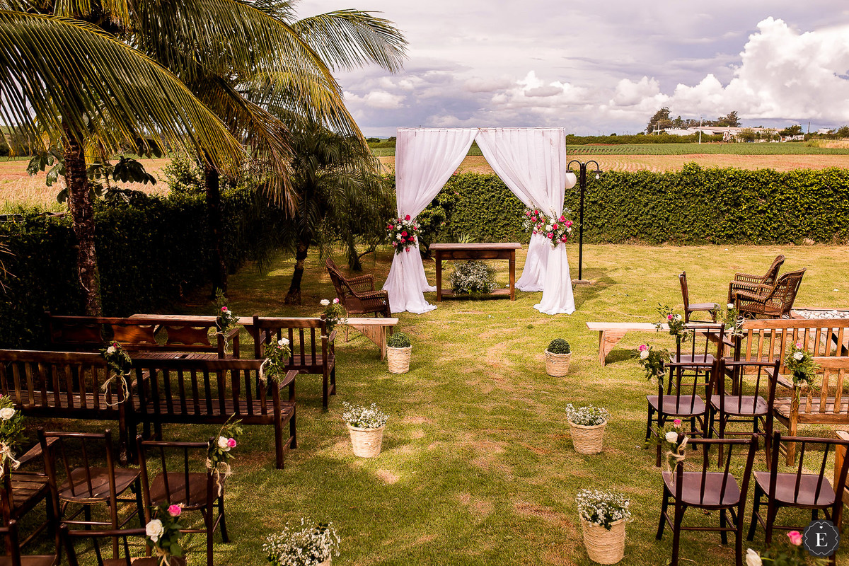 casamento de dia no campo, com cadeiras rústicas, panos e flores