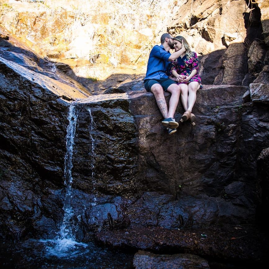 homem beijando testa da mulher na cachoeira