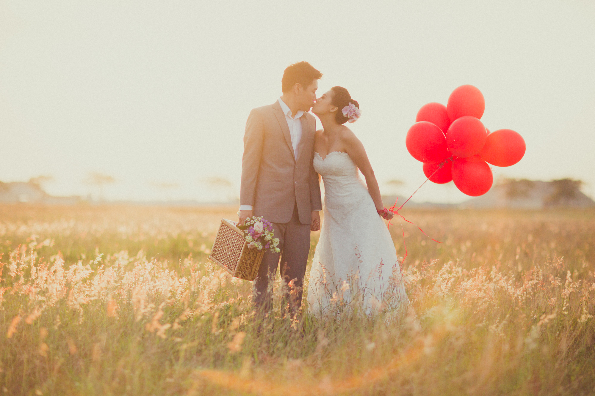foto no campo para pré-wedding casal segurando balões