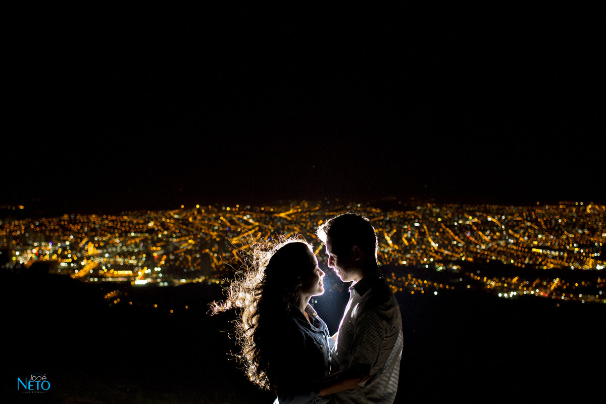 casal tirando foto de noite da vista da cidade